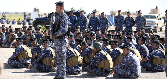 قوات الشرطة الاتحادية تستمع لإيجاز من أحد الضباط بمعسكر سبيكر في تكريت. أ.ب