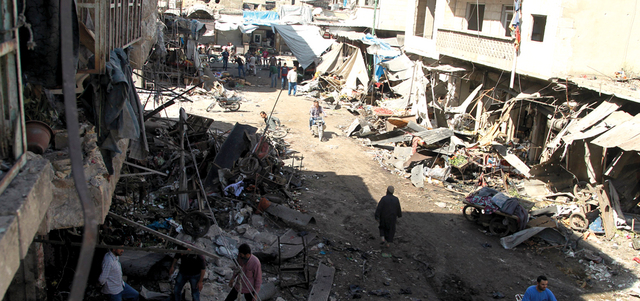 سكان يتفقدون الأضرار الناجمة عن غارة جوية على سوق للخضراوات  ببلدة معرة النعمان في ريف إدلب.    رويترز