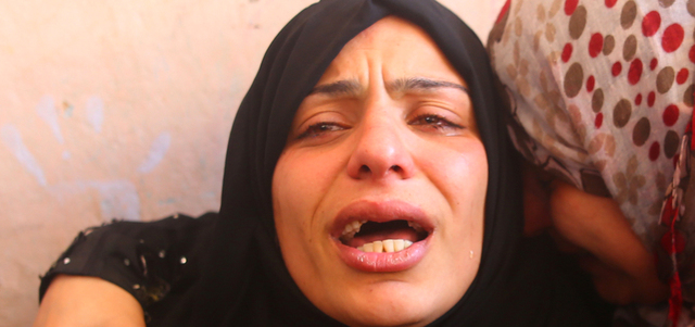 الذهول يبدو واضحاً على الأم المفجوعة بفقدان أطفالها الثلاثة.  أ.ف.ب