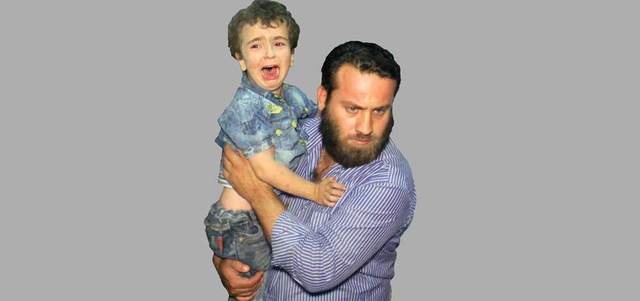 رجل يحمل طفلاً يبكي في المستشفى بعد غارات روسية استهدفت عدداً من المناطق في  مدينة إدلب. أ.ف.ب