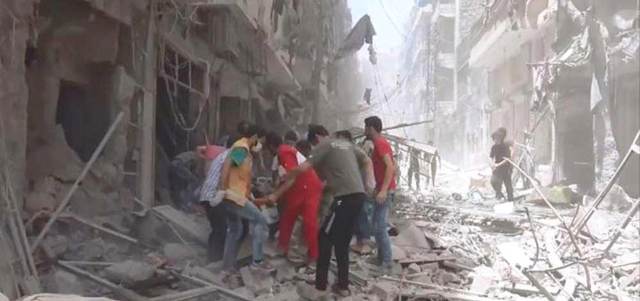 مسعفون يحملون أحد ضحايا الغارات على حلب. أ.ب