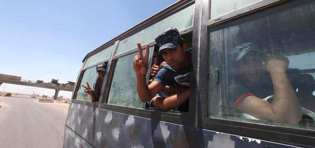 عنصران من قوات الأمن يرفعان شارة النصر على مشارف الفلوجة. رويترز