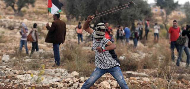 شبان يرمون الحجارة على جنود الاحتلال الإسرائيلي في الانتفاضة الفلسطينية الثانية التي قادها البرغوثي. أرشيفية