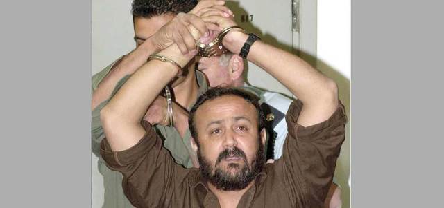 البرغوثي بين سجانيه يقول إن إسرائيل ستطلق سراحه عاجلاً أم آجلاً. أرشيفية