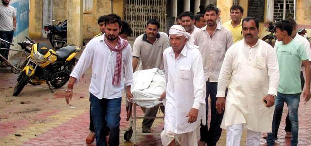 أقارب إحدى ضحايا الصواعق محمولاً على إحدى النقالات.  إي.بي.إيه