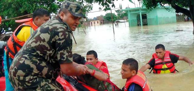 أفراد من الجيش النيبالي يجلون عدداً من النيباليين الذين حاصرتهم المياه. أ.ف.ب