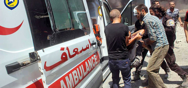 مسعفون خلال نقل ضحايا القصف في إدلب.  أ.ف.ب