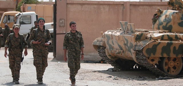 مقاتلون من «وحدات حماية الشعب» الكردية يدخلون حي غويران في الحسكة. رويترز