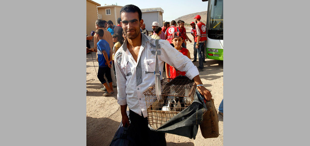 سوري يحمل معه حماماته خشية أن تموت. إي.بي.إيه
