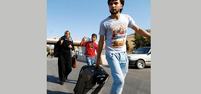 سوريون يدخلون تركيا عبر بوابة باب الهوى الحدودية.  رويترز