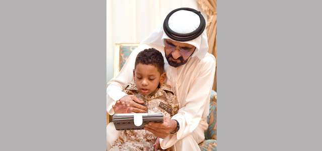 محمد بن راشد في لحظة أبوية حانية مع ابن الشهيد. وام
