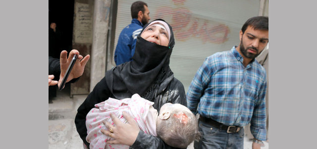 امرأة تبكي وهي تحمل جثمان طفلها الرضيع بعد انتشاله من تحت أنقاض مبنى تهدم بغارة لقوات النظام على حلب. أ.ف.ب