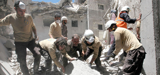رجال الإنقاذ يبحثون عن الناجين من تحت الأنقاض بعد أن قصفت الطائرات الروسية بلدة أريحا في محافظة إدلب أخيراً. رويترز