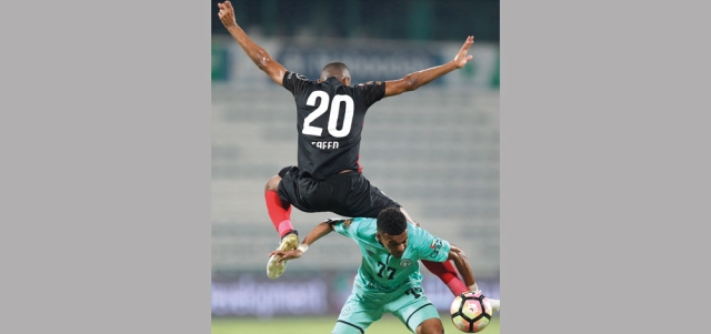 لاعب الأهلي سعيد أحمد يحلق عالياً لقطع الكرة من راشد حسن في مباراة الأهلي والشباب. تصوير: أسامة أبوغانم