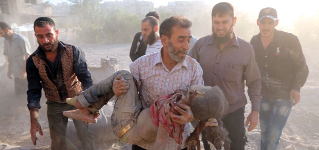 رجل يحمل جثة فتاة قتلت في غارة لقوات النظام على بلدة كفربطنا في الغوطة الشرقية لدمشق. أ.ف.ب