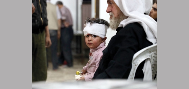 طفل سوري ينتظر الدواء بعد علاجه في مستشفى مؤقت إثر إصابته بغارة لقوات النظام على مدينة دوما بريف دمشق. أ.ف.ب