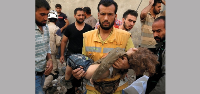 مسعف يحمل جثة طفل قتل بقصف لقوات النظام على حي كرم حميد الخاضع للمعارضة في حلب. رويترز