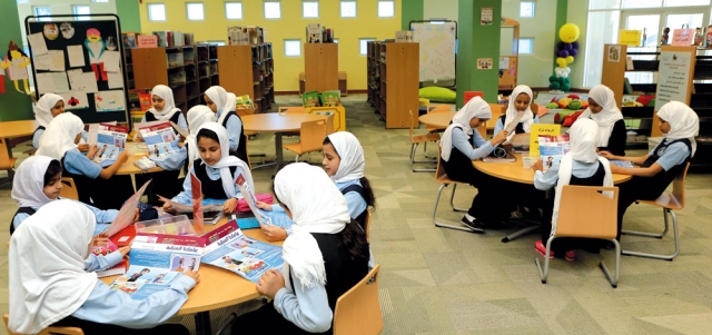 طالبات يقرأن ««عاملتنا المنزلية» ضمن مبادرة «طفلك يقرأ». تصوير: نجيب محمد