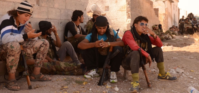 مقاتلون من المعارضة السورية يستريحون في قرية رائيل قرب بلدة دابق بريف حلب، بعد أن طردوا تنظيم «داعش» منها. أ.ف.ب