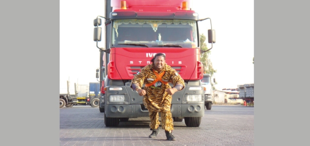 حسين شمشون أثناء جره إحدى الشاحنات.  من المصدر