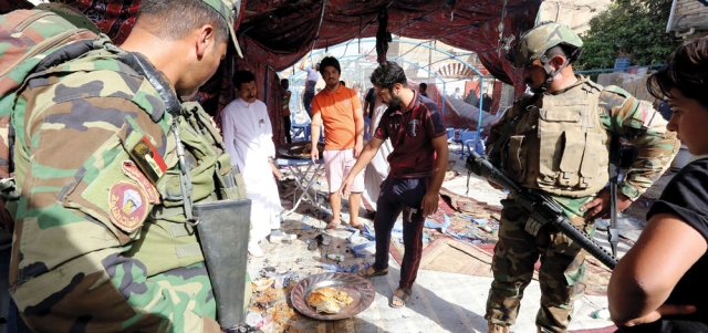 قوات الأمن العراقية تتفقد الأضرار في موقع التفجير الانتحاري. أ.ف.ب