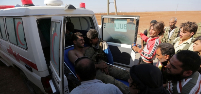 مقاتلون من المعارضة يسعفون زميلاً لهم أصيب في غارة لقوات النظام  على ريف حلب الشمالي. رويترز