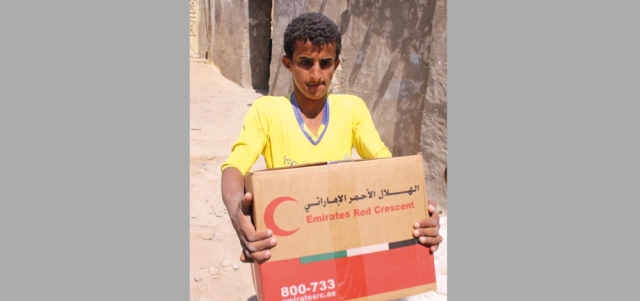مواطن يمني يحمل سلة مساعدات مقدمة من الإمارات. وام
