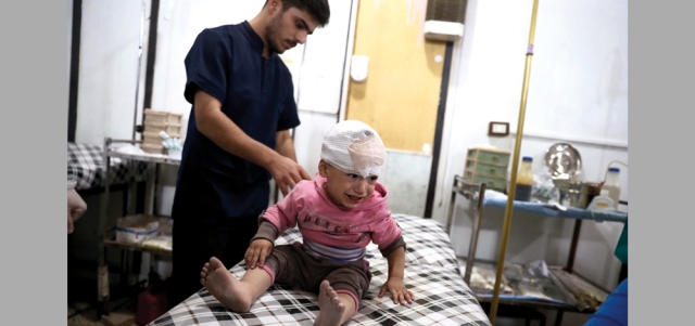 طفل سوري يبكي ويتلقى العلاج في مستشفى ميداني بعد إصابته بغارة لقوات النظام على مدينة دوما بريف دمشق.  أ.ف.ب