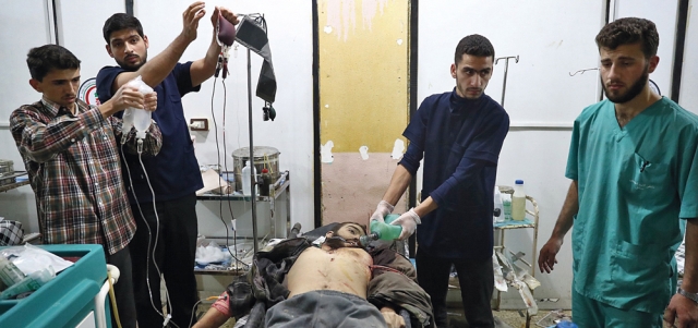 جريح يتلقى العلاج في مستشفى ميداني بعد إصابته بغارة لقوات النظام على مدينة دوما بريف دمشق. أ.ف.ب