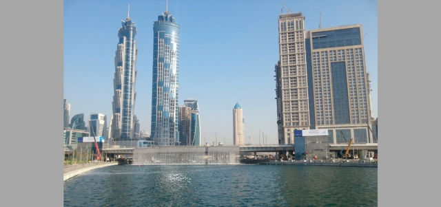 اختبارات تجريبية للشلال الذي ينهمر من جانبي الجسر العابر فوق القناة على شارع الشيخ زايد.  الإمارات اليوم