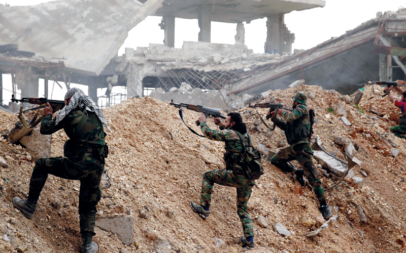 جنود من قوات النظام يطلقون النار خلال معركة مع المعارضة في الخط الأمامي بحي الراموسة شرق حلب. أ.ب