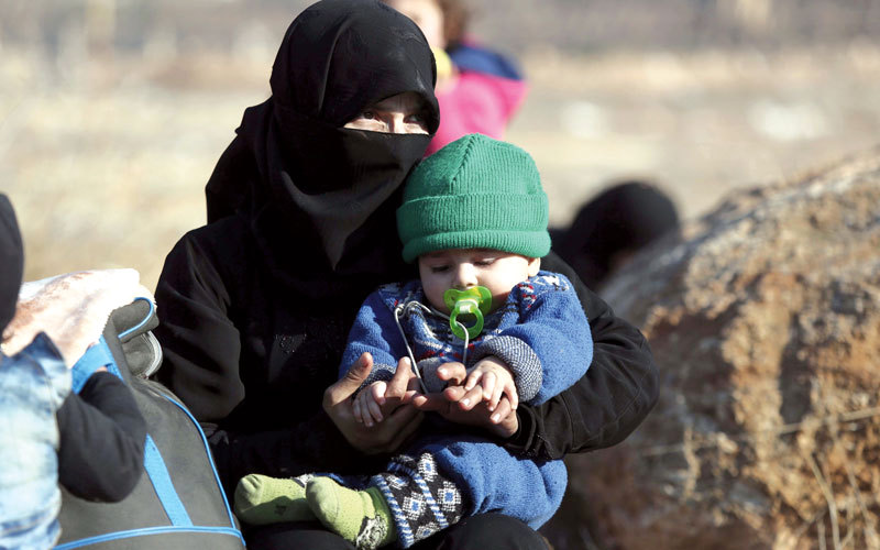 امرأة تجلس مع طفلها على الأرض في مخيم الراشدين للاجئين قرب إدلب بعد إجلائهما من حلب الشرقية. أ.ب