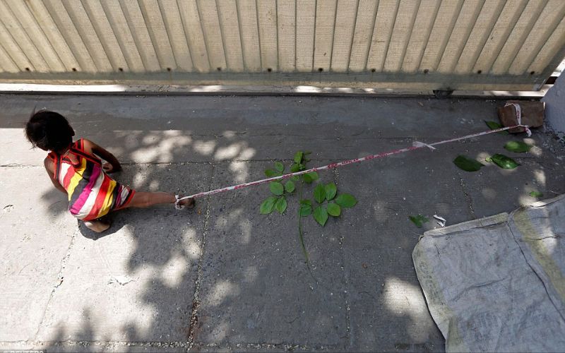 طفلة قيدت من قدمها بحجر حتى لاتهرب أو تضيع أثناء عمل أمها في إحدى شركات البناء. الهند.أبريل