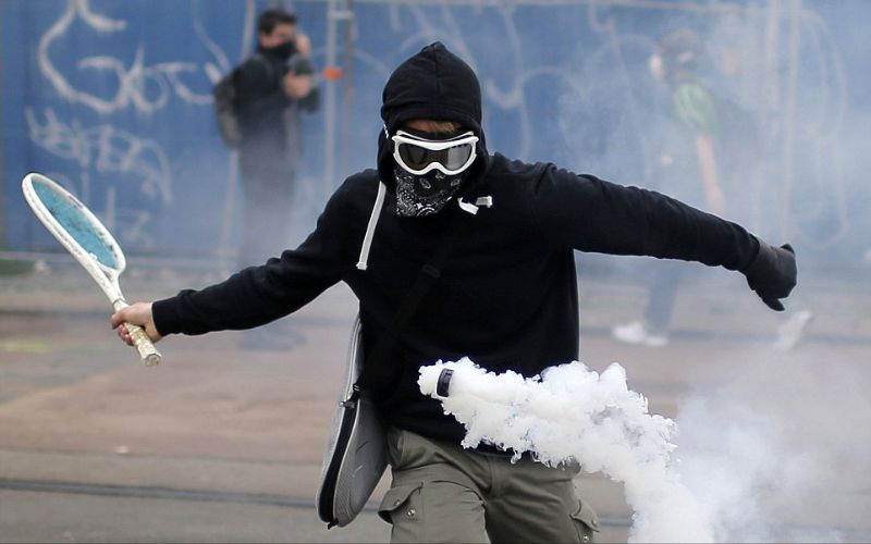 شاب يستخدم مضرب تنس لصد قنبلة غاز مسيل للدموع أثناء الاحتجاجات على مقترح  قانون العمل الحكومي في نانتس.فرنسا.يونيو