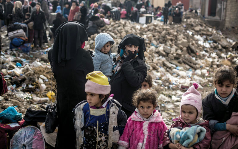 عراقية مهجرة من الموصل تنتظر مع أطفالها في نقطة تجمع للنازحين ببرطلة. أ.ب