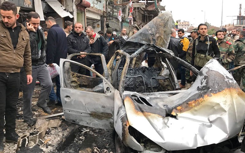 سوريون حول موقع تفجير السيارة المفخّخة في مدينة جبلة باللاذقية. أ.ب