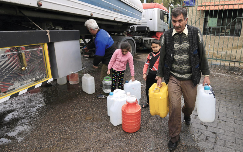 سوريون يحملون عبوات الماء مع استمرار انقطاعها عن دمشق منذ 22 ديسمبر الماضي. أ.ب