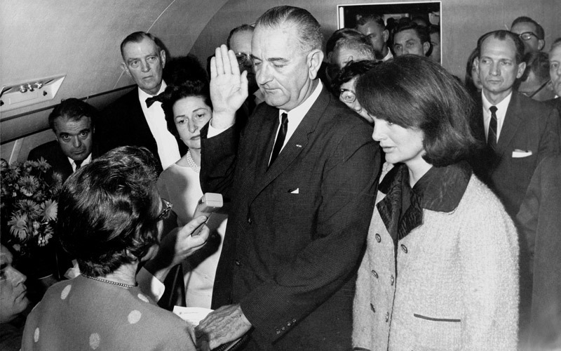 جونسون يؤدي اليمين أمام القاضية هيوز في الطائرة الرئاسية وبجانبه جاكلين كيندي. أرشيفية