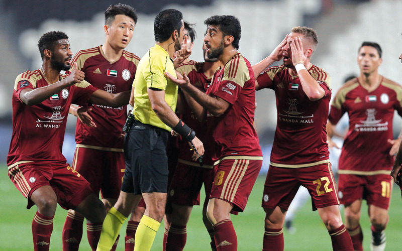 لاعبو الوحدة يعترضون على قرارات الحكم يعقوب الحمادي. تصوير: إريك أرازاس