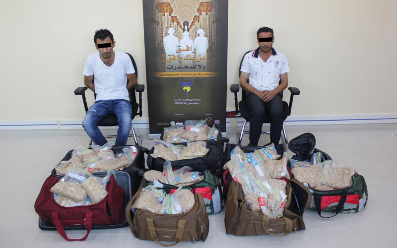 المتهمان في قضية «حقائب الموت» خلف المضبوطات.  من المصدر