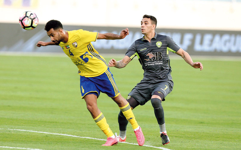 لاعب الظفرة يعقوب الحمادي يبعد الكرة قبل لاعب الوصل، البرازيلي كايو. تصوير: إريك أرازاس