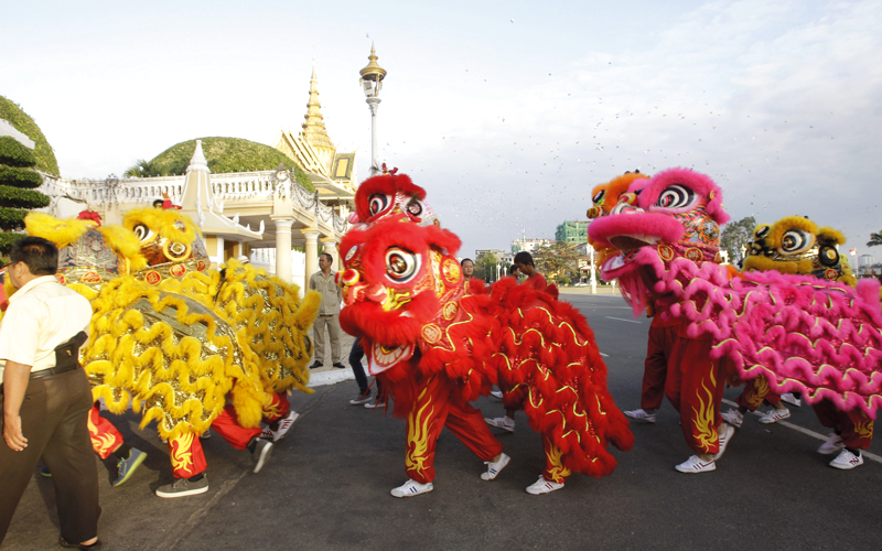 أعضاء من الجالية الصينية في كمبوديا يؤدّون رقصة الأسد التقليدية، عشية العام القمري الجديد، أمام القصر الملكي في بنوم بنه، كمبوديا.  أ.ف.ب