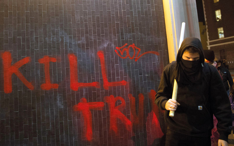 أحد المحتجين يحمل عصا استخدمها خلال المواجهات مع رجال الشرطة في الحرم الجامعي. أ.ف.ب