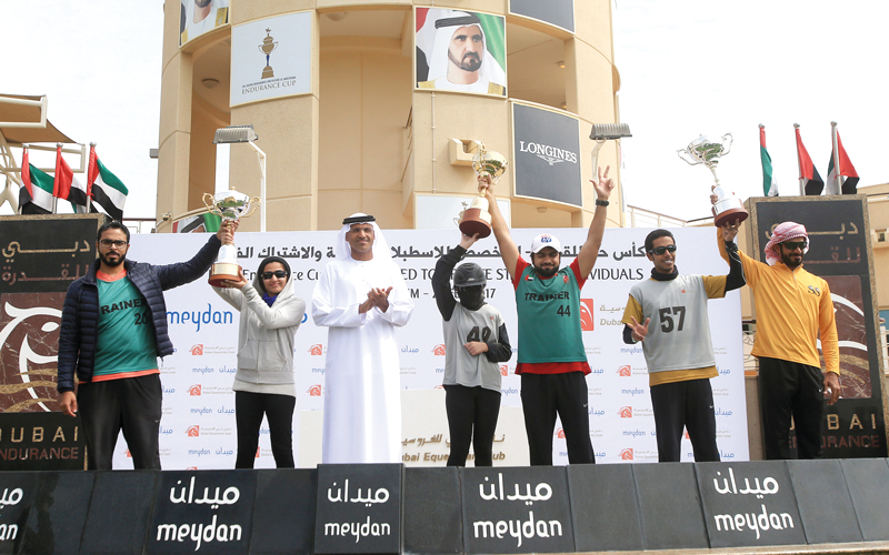 مدير نادي دبي للفروسية محمد العضب يتوسط أبطال السباق على منصة التتويج. تصوير: باتريك كاستيلو