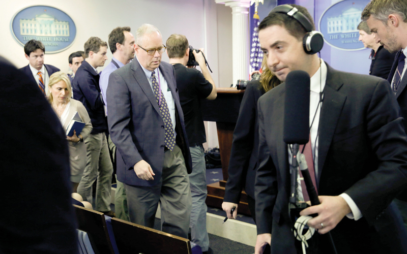 مندوبو الصحف المحتجون يغادرون قاعة المواجز الصحافية في البيت الأبيض.  رويترز