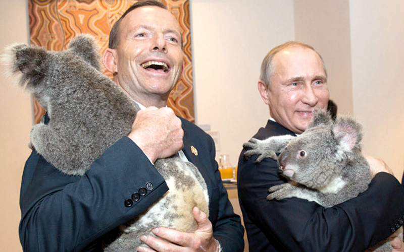 بوتين ورئيس وزراء أستراليا السابق توني أبوت يحتضنان دُبَّي «كوالا». غيتي