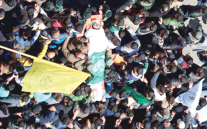 رايات الفصائل الفلسطينية توحّدت إلى جانب العلم الفلسطيني  في تشييع جثمان فقهاء.  الإمارات اليوم