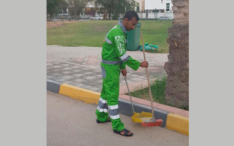 الشاب ينظف الشوارع تنفيذاً لعقوبة الخدمة المجتمعية. من المصدر
