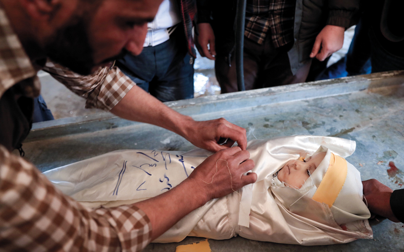 سوري يكفن طفلة قتلت في غارة لقوات النظام على مدينة دوما بريف دمشق. أ.ف.ب