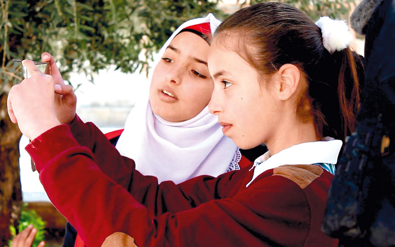 الطفلة أسيل ضراغمة وبجانبها زميلتها رفيف زيدان أثناء التدريب على توثيق الانتهاكات بواسطة الكاميرا. من المصدر